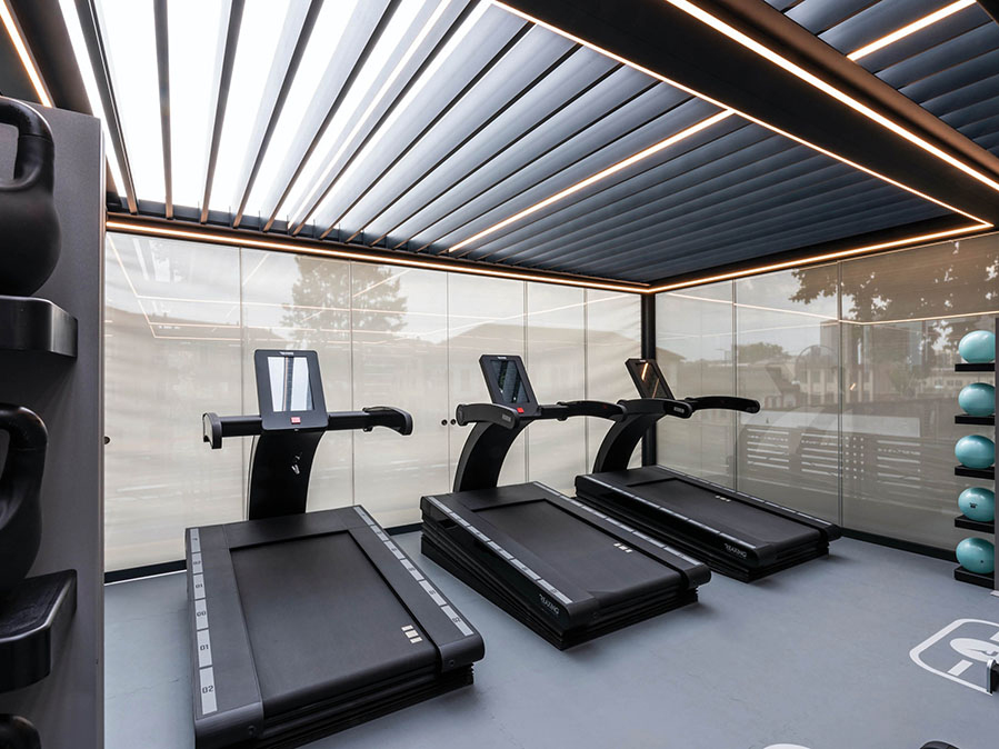 Modernes Home-Gym unter RENSON Lamellendach - wetterunabhängiges Training im Garten, geplant von Stilgarten in Glienicke und Mühlenbeck.